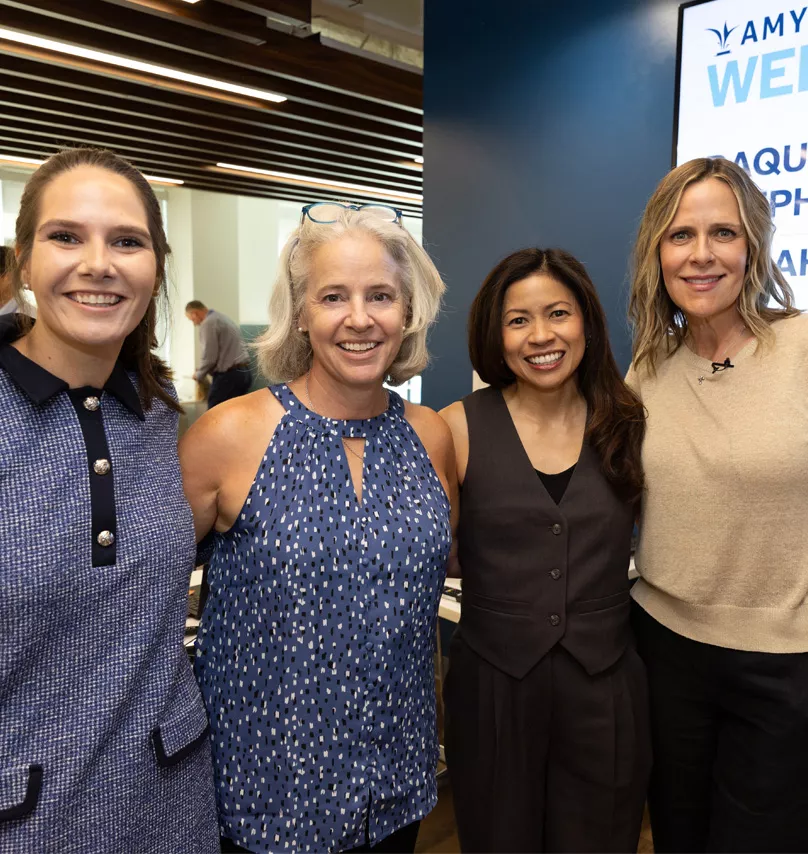 Employees posing at Amylyx' office with guests from the community.