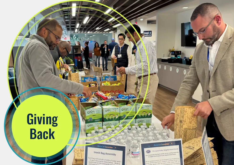 Four Amylyx employees preparing care packages consisting of water and healthy snacks for kids attending grade school in the Greater Boston area.